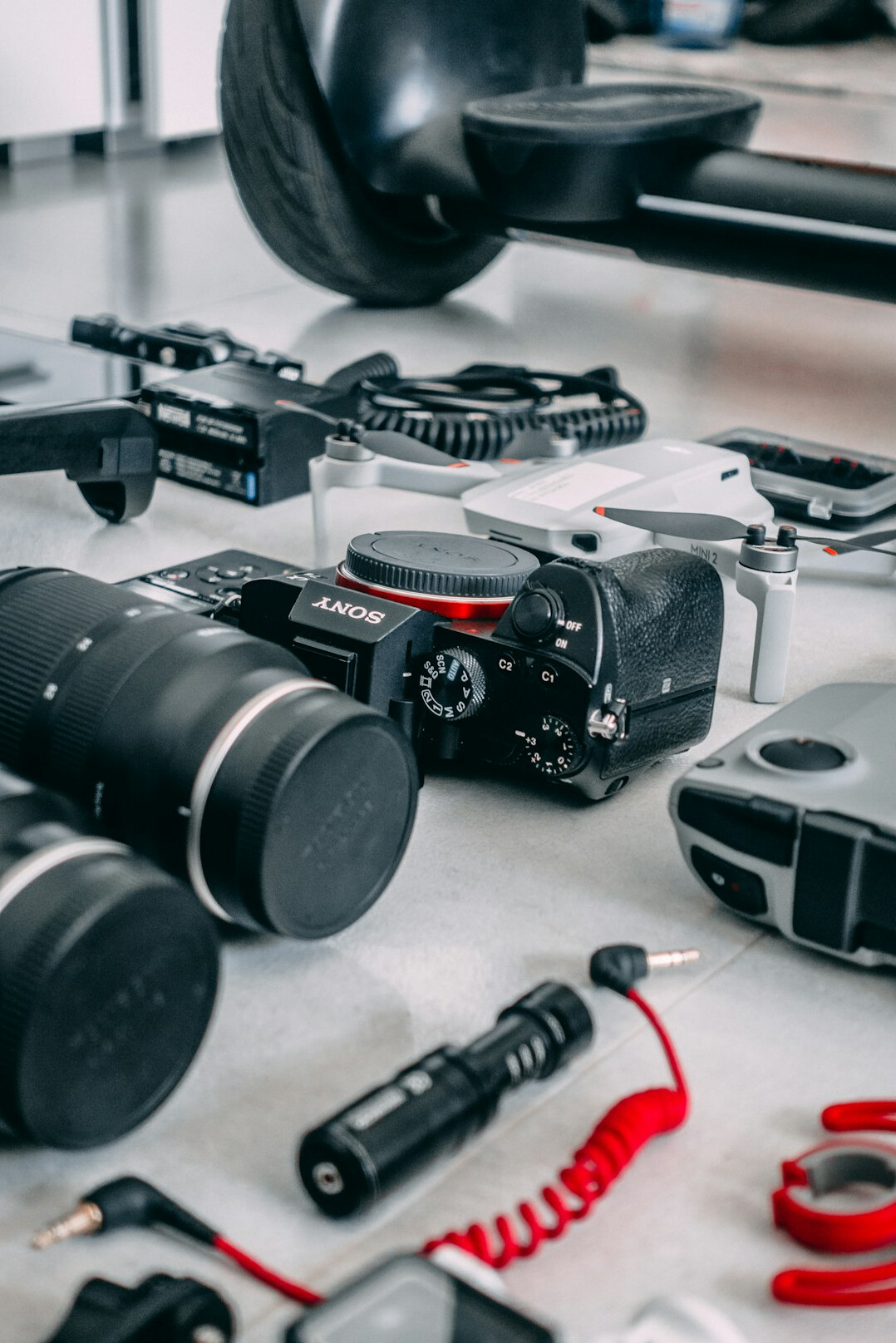 Flat lay of professional filmmaking equipment including camera lenses and audio recorder